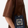 Lomme med snøring i klassisk kalveskinn og raffia Lomme med snøring i klassisk kalveskinn og raffia